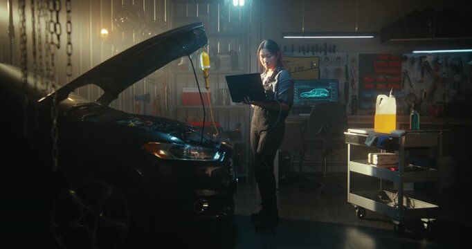 Female Auto Expert Conducting Computer Diagnostics on Car With an Open Hood. Girl Uses Laptop and Specialized Software to Identify Engine Malfunctions and Optimize Performance. Female Empowerment.