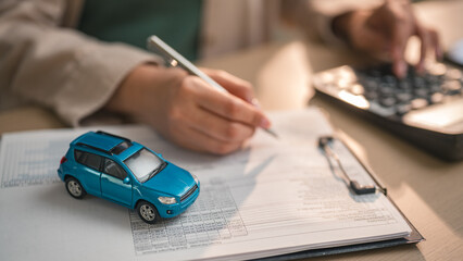 Fototapeta premium Customer signing car purchase agreement with auto loan and insurance policy, symbolizing vehicle finance, ownership transfer and dealership transaction in automotive business.