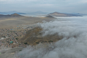 Aerial view of desert mountains and city with many low clouds © WILL PHOTOGRAPHY