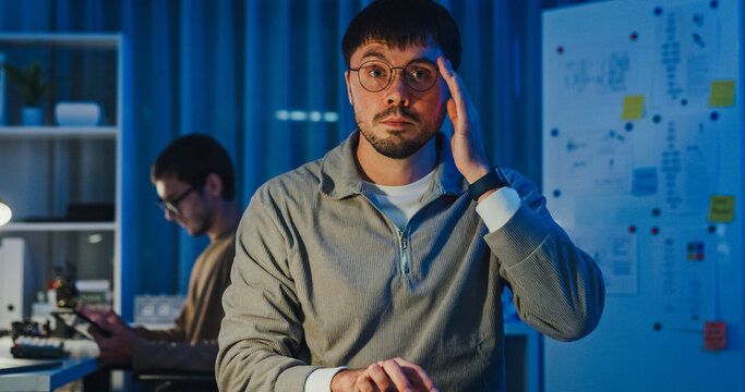 Team adult male freelance developer work late typing write prompt AI bot app program nomad terminal code at office night. Artificial intelligence dashboard, robotics, user interface, machine learning.