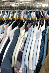 Neatly arranged men's professional shirts featuring blue and white patterns on a clothing rail