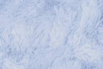 Close up view of soft light blue fluffy faux fur textile background texture ideal for warmth © reddish