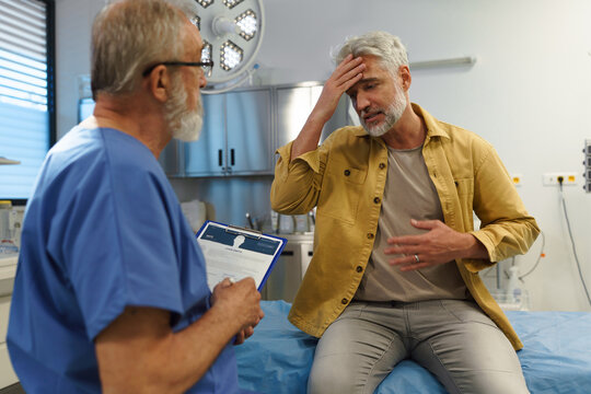 Patient sitting on examination table, describing symptoms to doctor.