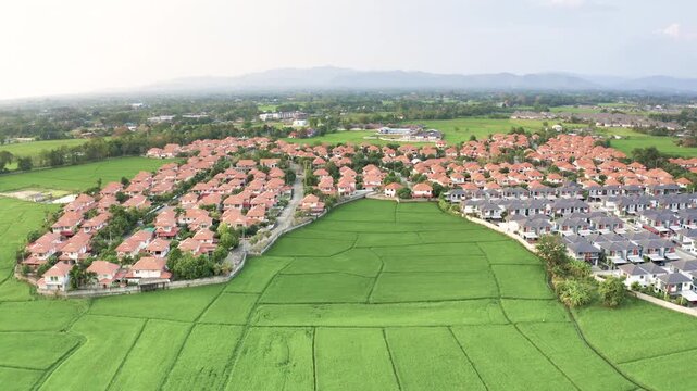 Land and houses in San Sai District, Chiang Mai, Thailand, photographed in March 2021.  Nature oriented lifestyle with nearby rice fields, mountains and rural landscapes, charm of Northern Thailand.