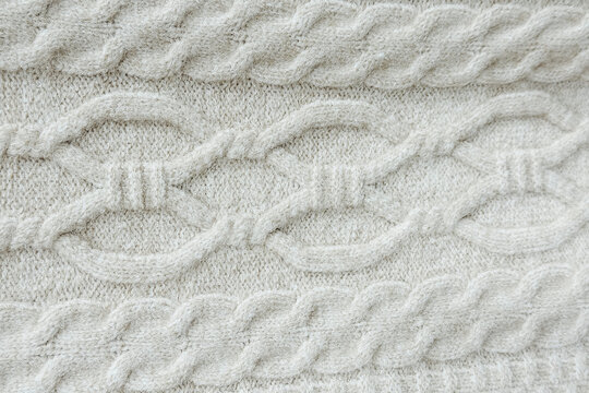 Close up cream knitted wool fabric texture with cable pattern