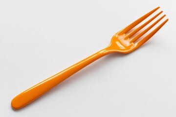 Golden plastic fork on white background.