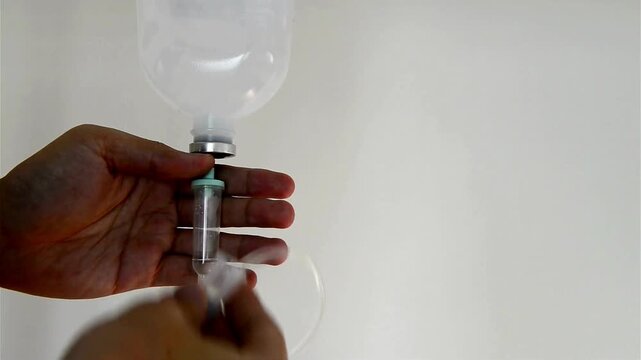 drip chamber dripping into patient A mixture of sodium chloride or salt and water Close up on Set IV fluid intravenous drop saline on a dark blue