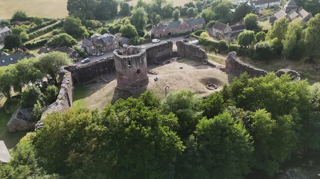 High reveal of the majestic ruins of Skenfrith Castle featuring tower with views over the village on sunny summer day