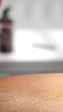 quadriceps sports massage using whole forearm technique in studio, close-up vertical