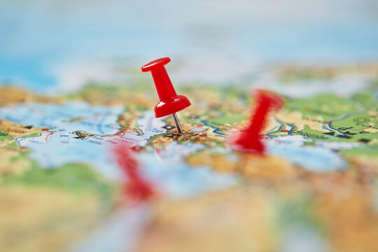 Multiple push pins marking locations on world map travel route and destination concept