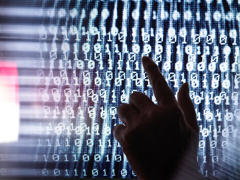 Cropped image of human hand touching computer screen