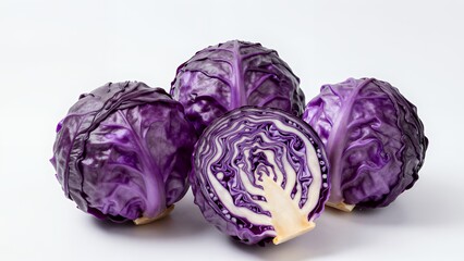 Obraz premium Four Fresh Purple Cabbages with One Halved Showing Cross-Section Against White Background
