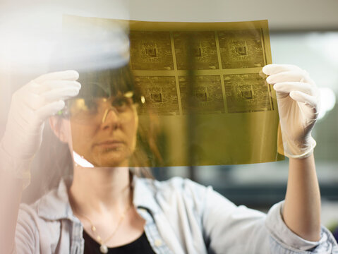 Female technician controlling foil printing with circuitry