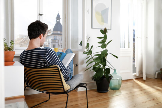 Man sitting at home, using laptop