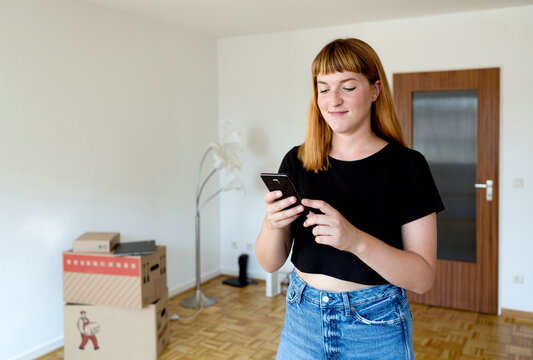 Portrait of smiling young student using smartphone during move