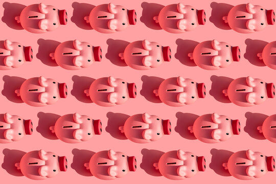 Seamless pattern of rows of piggy banks against pastel pink background