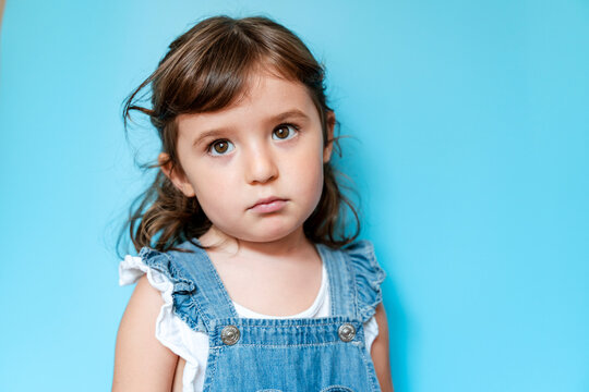 Portrait of sad girl, blue background