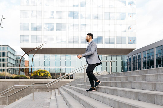 Casual young businessman walking down stairs in the city