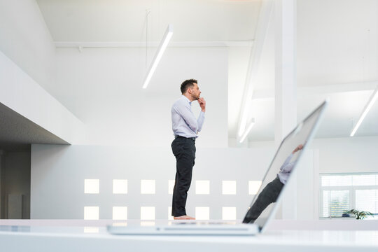 Thoughtful businessman at laptop in office