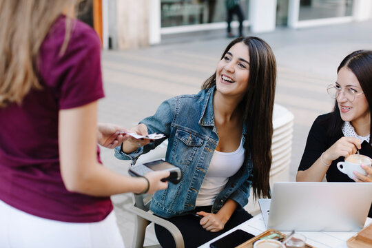 Young woman paying in a cafe