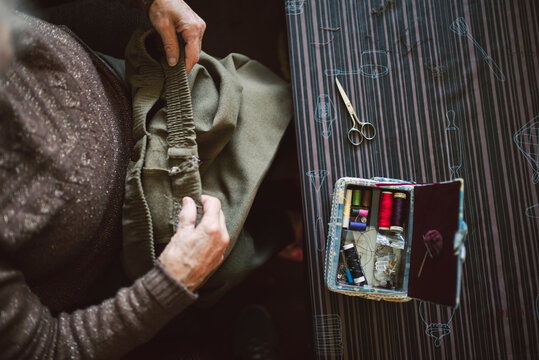 Senior woman with sewing kit, top view