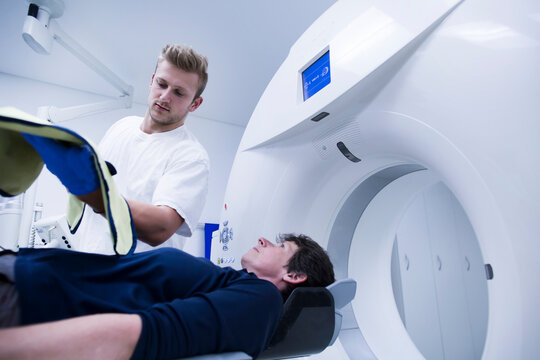 Patient in hospital during CT examination and radiologist