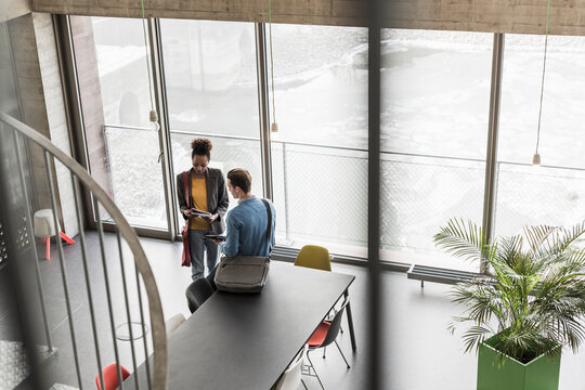 Young business people discussing files in office