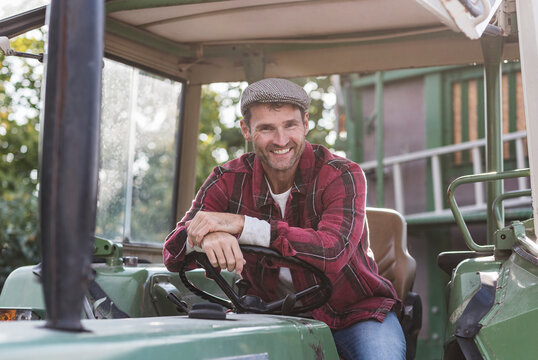 Portrait of confident farmer on tractor