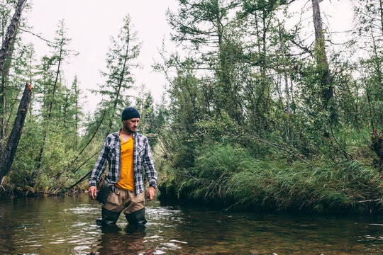 Man standing in river with waders