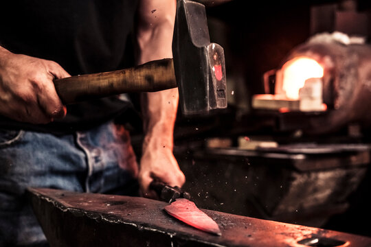 Knife maker at work, steel splinter during hammering damask steel