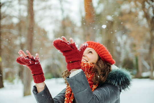 Happy woman catching snowflakes