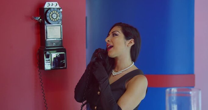 A young woman wearing headphones singing passionately in a soundproof recording booth.