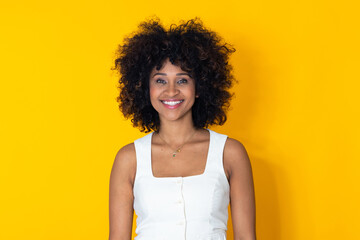 smiling young Latina woman with afro hair isolated on background