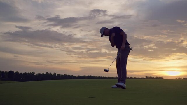 Professional young male golfer swings his club on scenic golf course. 