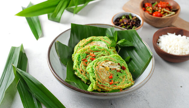 Delicious and vibrant green Indonesian serabi pancakes served with a side of rice and spicy sambal