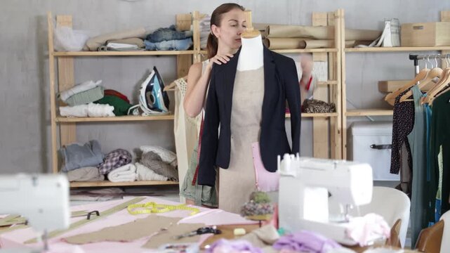 Girl designer tries on jacket for mannequin, visual perception of finished product. Self-control in process of making clothes
