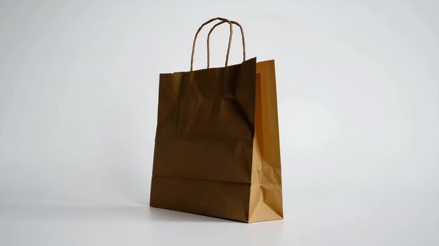 Brown kraft paper shopping bag with handles isolated on white background for eco friendly packaging
