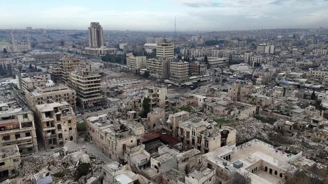 Aerial drone shot over Aleppo, Syria, showing a stark contrast between devastated residential blocks and more modern buildings on the city horizon