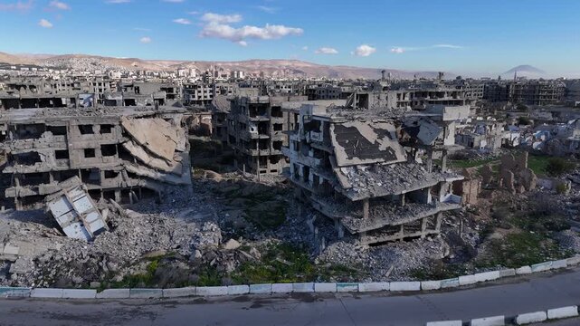 aerial drone shot over Jobar, Damascus, showing the extensive war destruction of residential buildings and urban landscape in Syria
