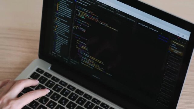 Programer Hacker typing on a laptop keyboard at night Man programmer hands coding html writing program code sitting at workplace in office, background