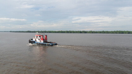 Tugboat Towing on Wide River with Copy Space, Marine Transport and Logistics Concept © Clemens