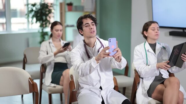 Medical professionals use smartphones during training sessions. Modern technologies in corporate training, students scan a QR code during a lecture. High quality 4k footage