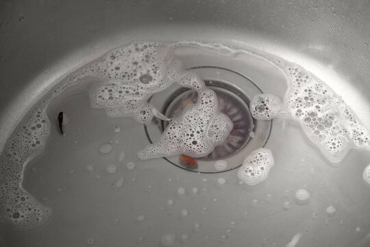A clogged kitchen sink with food and food debris.