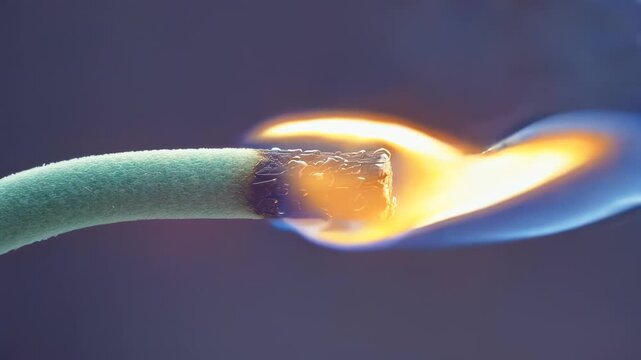 Burning incense stick with vibrant flame and smoke rising, showcasing the gradual ignition process in a dimly lit environment, creating a serene atmosphere