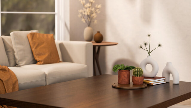 Cactus and pot plant on tray with books and creative vases on wooden table aside sofa in living room