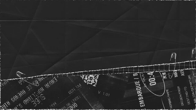 Artistic composition of torn ticket and paper with safety pins in black and white