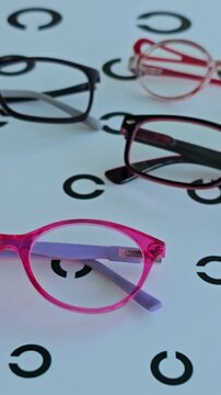 Different styles of eyeglasses displayed on a patterned surface in a shop at midday