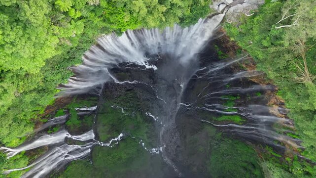 Cinematic aerial panorama of Tumpak Sewu Waterfall &ndash; Majestic canyon with massive cascades, tropical mist, and lush jungle in East Java, Indonesia