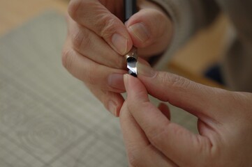 プラモデルのパーツをカッターを使って削る様子の手元