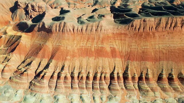 Aerial drone view of layered sandstone cliff formations in Zhangye Danxia Geopark, Gansu Province, China